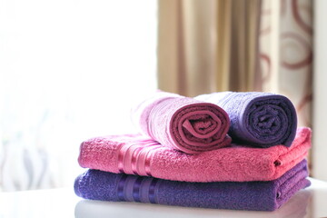 Obraz na płótnie Canvas folded pink and purple towels with copy space