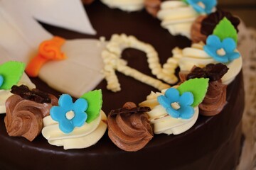 Beautiful chocolate birthday cake with flowers and number 12. Close up.
