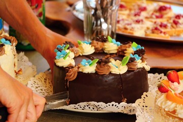 Slicing a beautiful chocolate birthday cake. Close up.