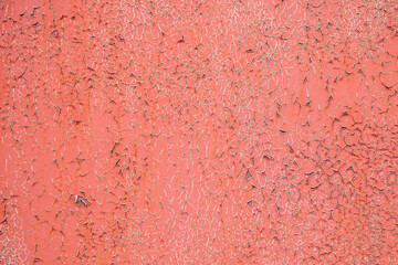 Weathered orange painted crumbling wall close up