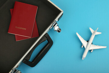 Conceptual photo of a tourist trip. foreign passport, and toy plane on a blue background with copy space