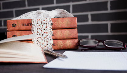 Book and black note with pen. Literature for the holidays and summer. Notes and quotes. Books on the dark table.