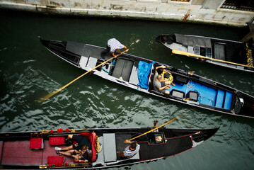 Obraz premium Venice, Italy - August 28, 2018. Tourists in gondolas in a narrow canal in Venice.