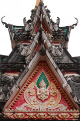 Multi-level roof top tower of a religious building of a temple showing praying buddha images in Siamese Lao PDR, Southeast Asia