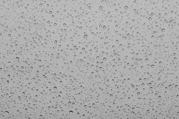 Water droplets on a car window close up. Raindrops on a glass surface as a background