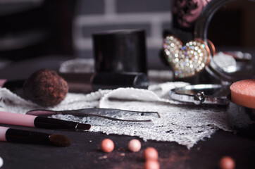 Cosmetics on a dark background, close-up. Face care, make-up. Items for applying makeup. The world of a woman.