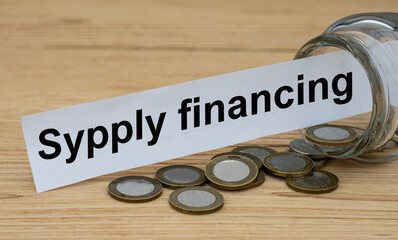 SYPPLY FINANCING words on a white strip of paper with a can of money