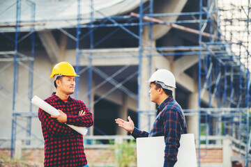 Engineers are discussing a new project. With a technical blueprint, her male project manager explains the job description. Office of Industrial Design Engineering