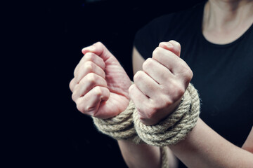 Hands of a victim woman tied up with rough rope. Stop abusing violence concept
