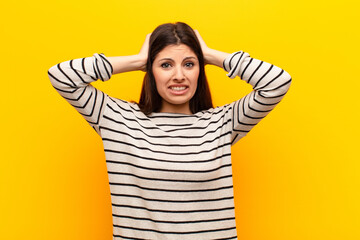 young pretty woman feeling stressed, worried, anxious or scared, with hands on head, panicking at...