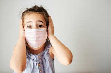 Girl with mask and surprise gesture prepared to avoid contagion before going outside