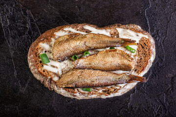 Sandwich with sprots on rye bread lies on a concrete background