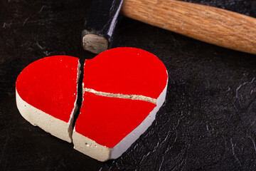 Red stone heart broken by hammer
