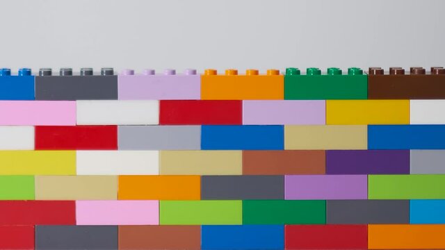 plastic building block. plastic brick wall. Wall from Plastic building blocks isolated. Suitable for greetings card, holidays. White background. stock footage. Close up video.