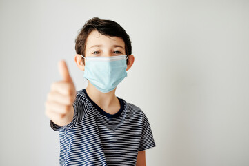 happy boy and with ok sign with her protective mask to avoid contagion against the virus