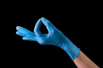 Doctor's hand in sterile medical gloves in gesture of okay isolated on black