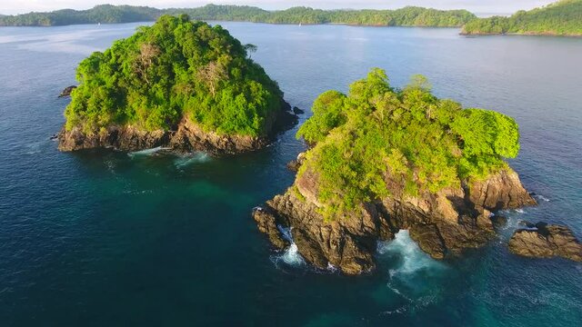 Forward Flying Aerial View of Cavada Island (Isla Secas) Wave Crashed Water Edge with Islands and Boats in the Background

