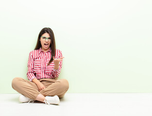 young pretty woman looking angry, annoyed and frustrated screaming wtf or what‚Äôs wrong with...