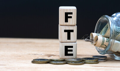 FTE on cubes on the background of a capacity with money