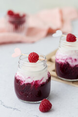 Raspberry smoothie, milkshake in a glass jar on a dark wooden background.