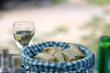 Rustic basket with slices of homemade bread, served on a table outdoor. Selective focus.