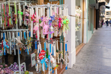 Girl tourist walking in the old souvenir market. Woman hand choosing colorful Easter candles in the Cretan store.