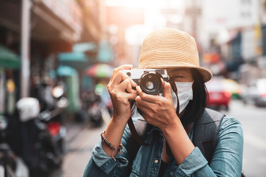 Asian women wearing surgical face mask traveler with camera travel of lifestyle portrait , outdoor summer concept