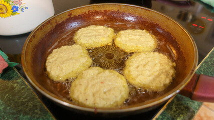 Potato pancakes are fried in a hot pan. Top view. Kitchen concept.