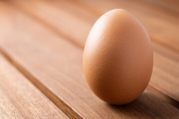 fresh raw chicken egg on a wooden  brown table as a background. concept of organic food, good health and high protein for cooking breakfast