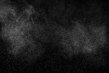 Abstract splashes of water on black background. Freeze motion of white particles. Rain, snow overlay texture.