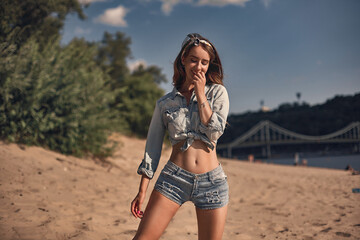 Young girl smiling at the beach wearing jeans