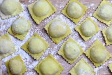 Cooking ravioli at home. Uncooked ravioli on a wooden board.