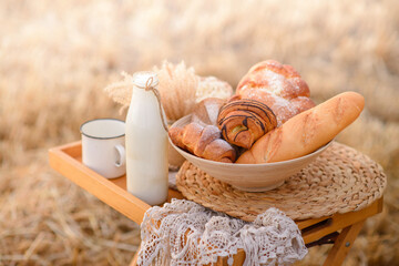Composition from an assortment of fresh bread on a background of a mowed field of wheat.
