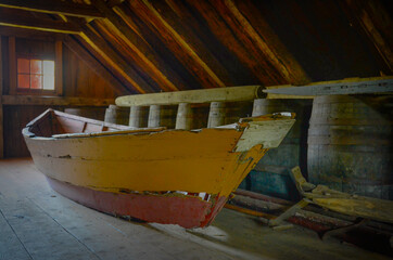 Fototapeta na wymiar very old deteriorated boat in the loft of a farmhouse in the Acadian Village, New Brunswick, Canada