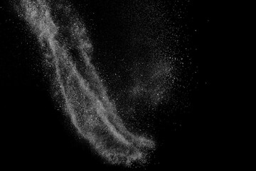 Freeze motion of white particles on black background. Powder explosion. Abstract dust overlay texture.