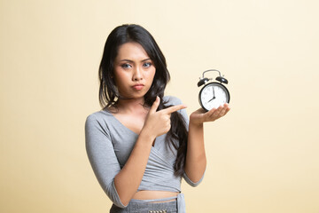 Angry young Asian woman point to a clock.