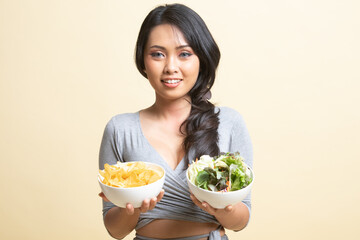 Young Asian woman with potato chips and salad.