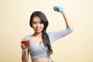 Healthy Asian woman with dumbbell and  tomato juice.