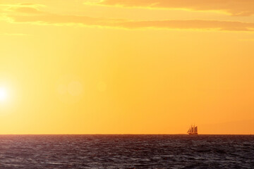 Sail boat on the horizon at sunset