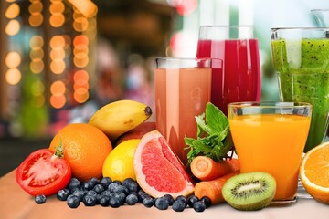 Composition of fruits and glasses of juice on the desk