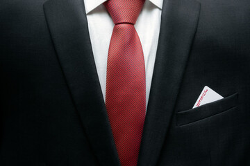 Business man in suit with jocker in the pocket of his jacket.  Metaphor to confidence in winning. Businessman ready for risk and development. Self-assurance concept.