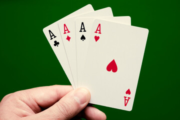 Four aces poker cards close up on green background. Four of a kind conbination in poker game.