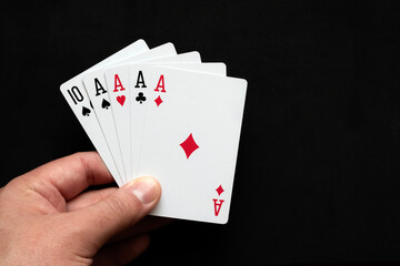 Fototapeta premium Four aces poker cards close up on black background. Four of a kind conbination in pocker game. Poker combinations concept.