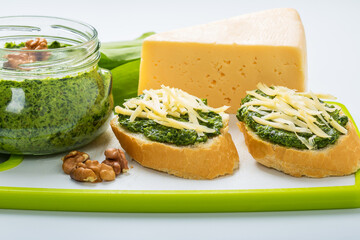 Slices of baguette topped with wild garlic pesto and cheese