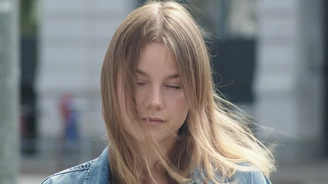 Beautiful Young Woman Looking into Camera with Slowmotion Wind in her Hair.