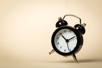 black vintage alarm clock falling to the floor with a colored background
