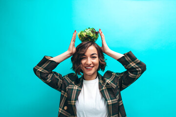 Happy healthy young woman eating natural salad wearing casual isolated over blue background. Healthy lifestyle concept