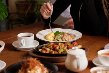 Female hands holding fork and knife, close Up. Woman eating business lunch, dinner at restaurant.