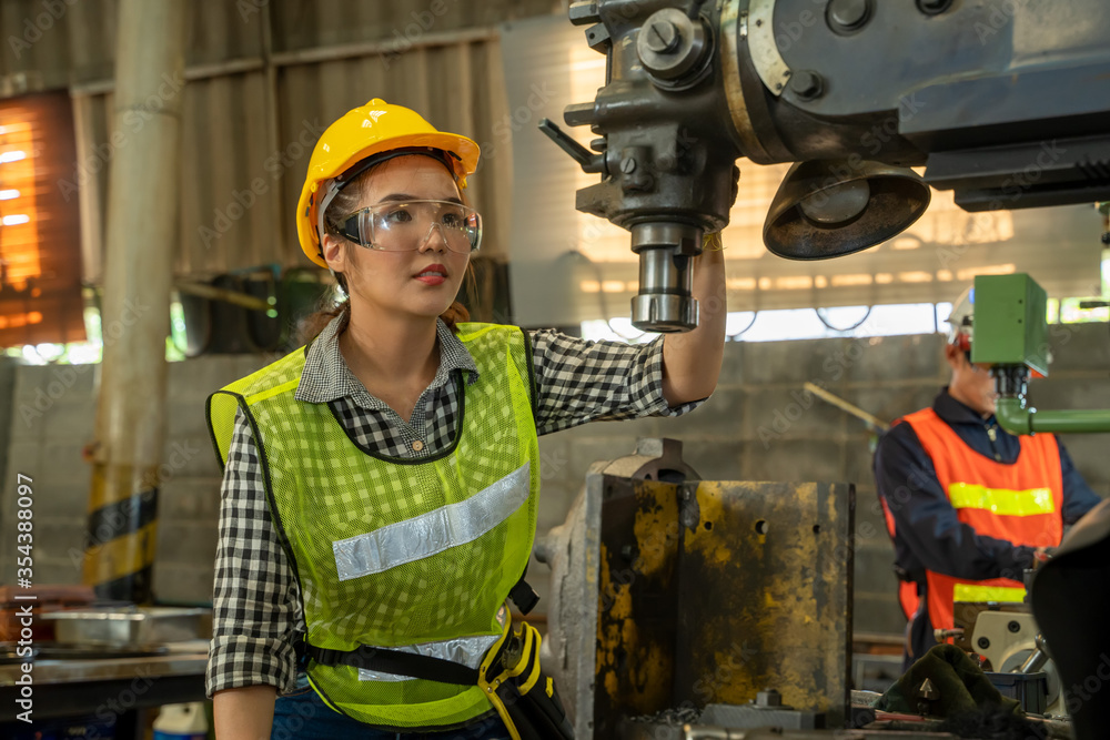 Poster Female Mechanic working and checking machine in factory.