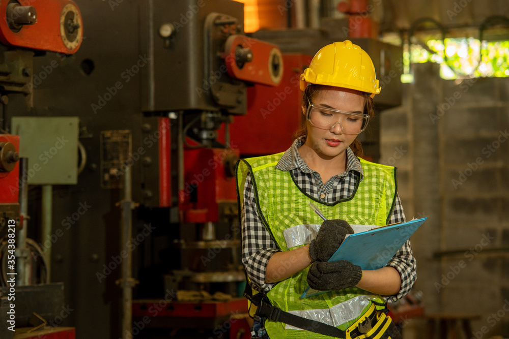 Poster female mechanic working and checking machine in factory.